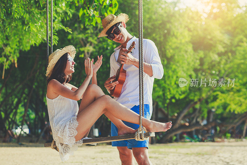 年轻的亚洲幸福夫妇在海滩上放松，情侣在爱情蜜月假期和旅行的概念