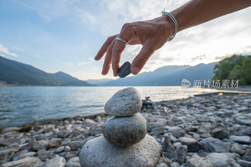 人在湖边堆积岩石的细节