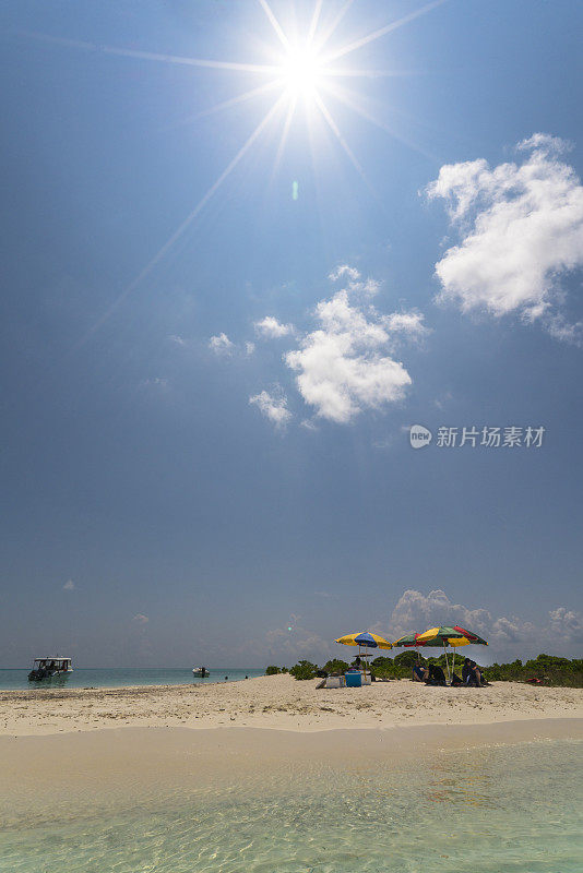 在马尔代夫马夫什岛附近的沙滩上，游客们在五颜六色的保护伞下休息