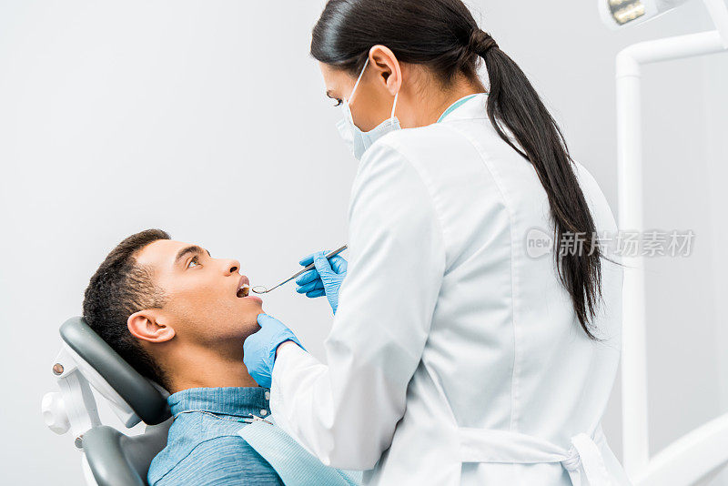 女牙医在乳胶手套检查非洲裔美国病人
