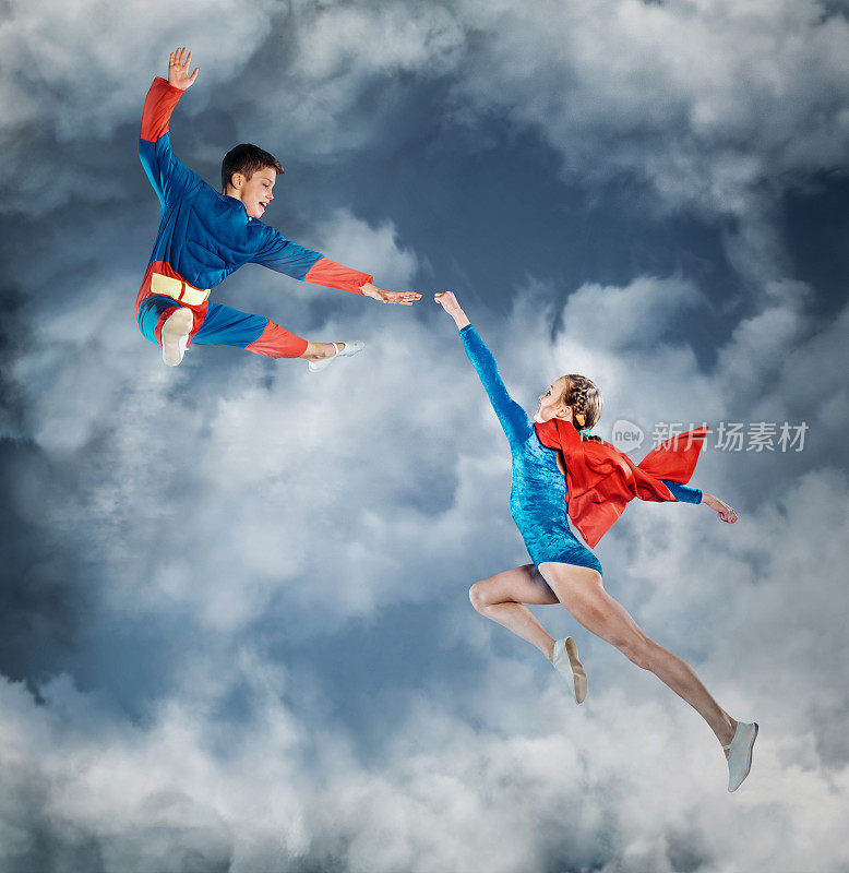 穿着超人衣服的有趣孩子在天空中飞翔。