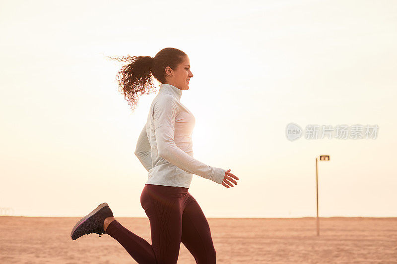 一位在巴塞罗那海滩附近跑步和锻炼的妇女。