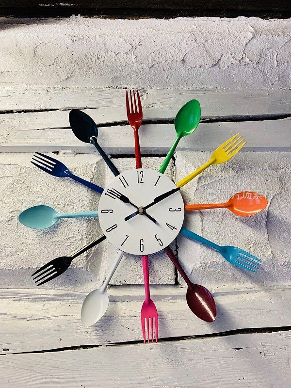 时钟与五颜六色的勺子和叉子