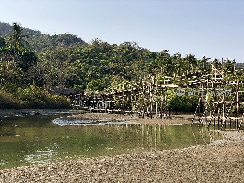 热带海滩岩石池泻湖椰子树，岩石，竹桥和金色的沙像天堂般的海滩度假照片，假日在果阿度假，Palolem海滩，南印度，海岸街道，天然岩石反射水面涟漪