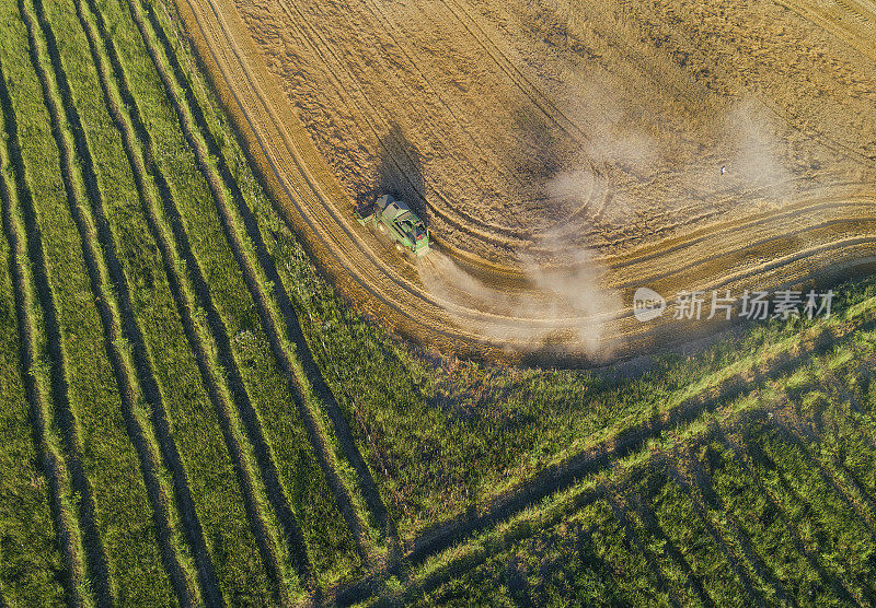 鸟瞰图一组联合收割机在日落后收获农地。夏季。耕地中的农业设备。夜间。工作到很晚。