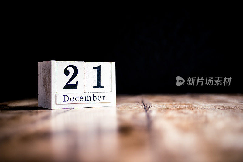 12月21日，12月21日，12月21日，12月1日-白色方块日历在古董桌上-日期在黑暗的背景