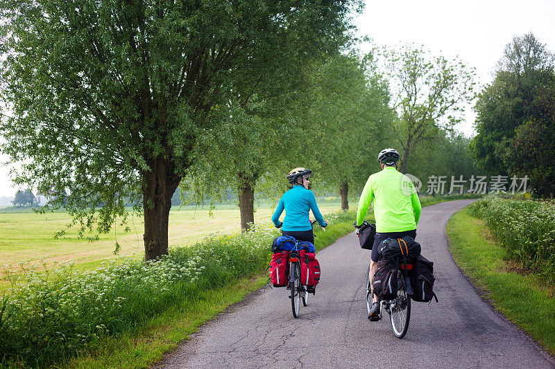 积极的资深自行车手与头盔，背带，齿轮在乡村车道