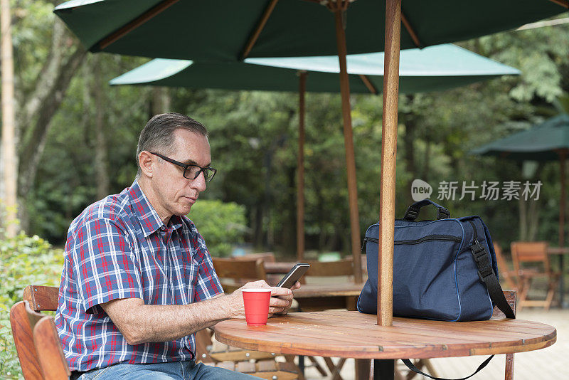 拉丁裔男子在一家漂亮的餐厅查看手机