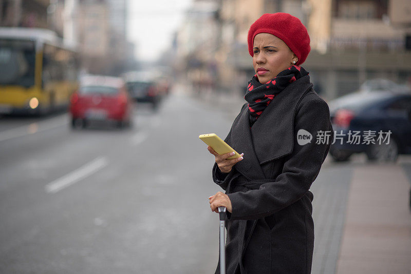 漂亮的肤色女人使用手机应用程序得到一个出租车