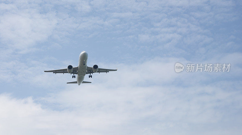 客机在飞行中。飞机在云层之上的高空飞行。飞机的底部视图。