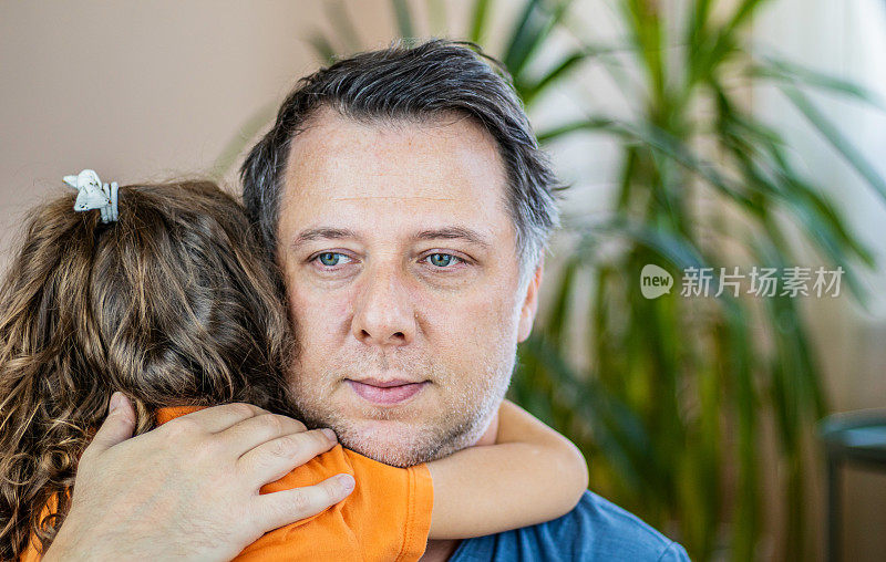 小女孩拥抱她的父亲并亲吻他。家庭和父亲节的概念。