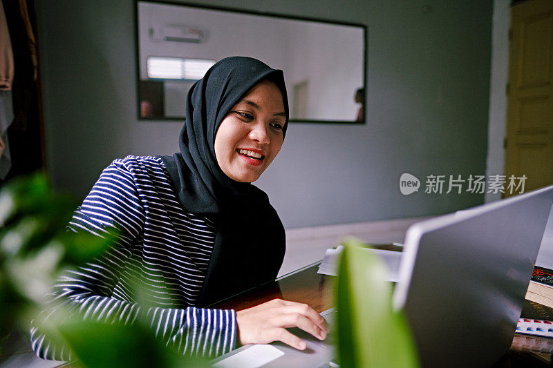 美丽的亚洲女人网上购物使用笔记本电脑