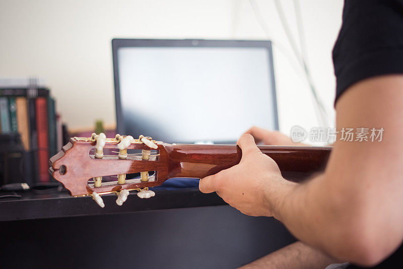 年轻人弹吉他，在线上音乐课。