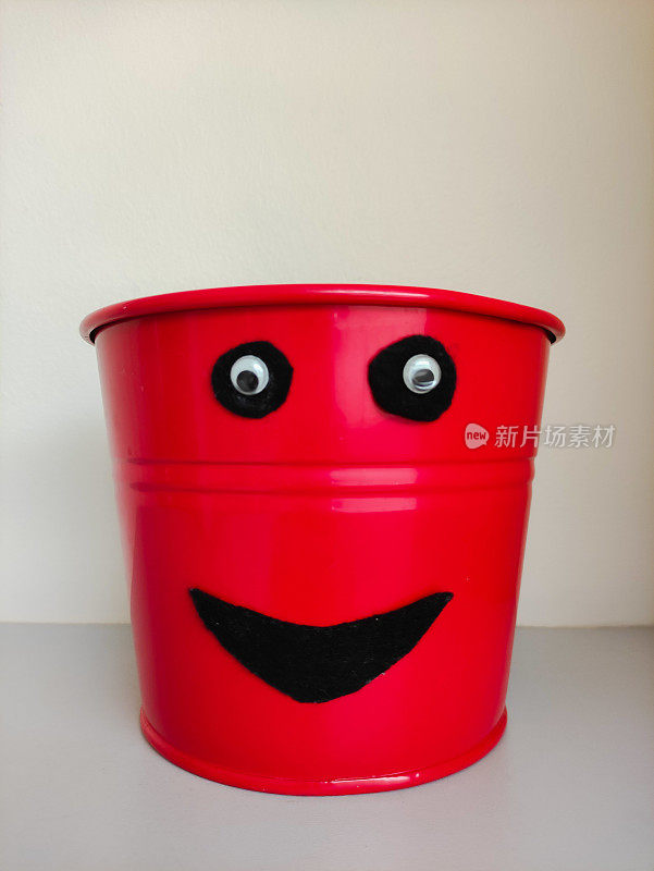 红色金属桶与快乐的脸