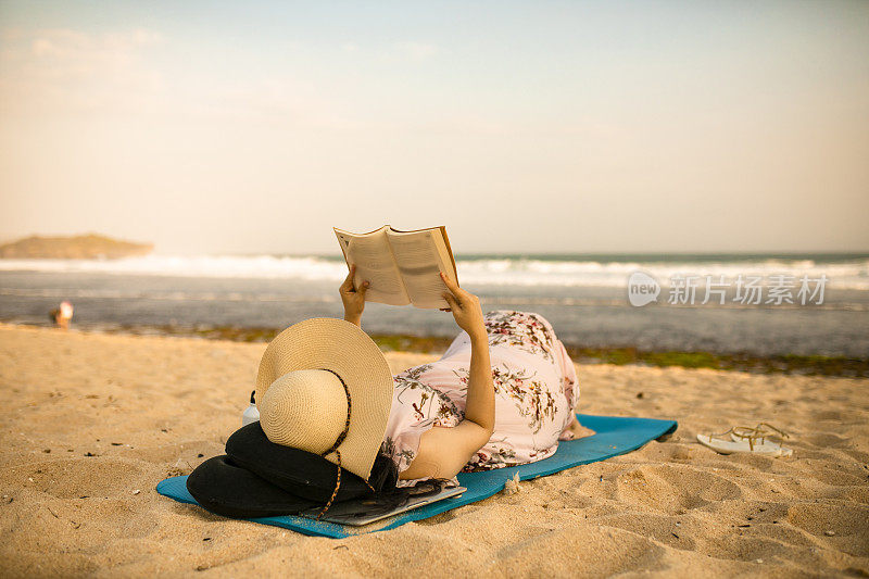 亚洲孕妇放松和躺在沙滩上享受日落