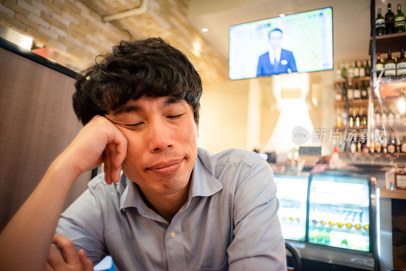 一名亚洲男子在餐厅等待用餐