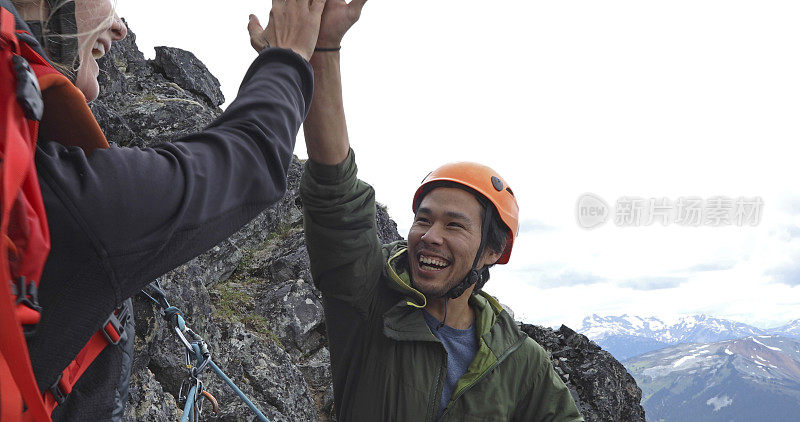 登山者朋友在山脊上击掌