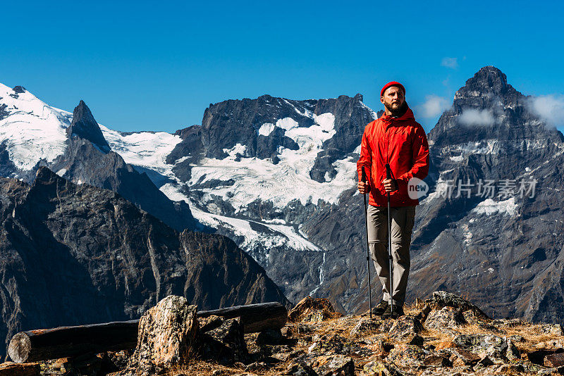 一个拿着北欧手杖的男人在山上。一个在高加索旅行的人。山运动。山旅游。徒步旅行。去山上的旅程。北欧人在山中行走。