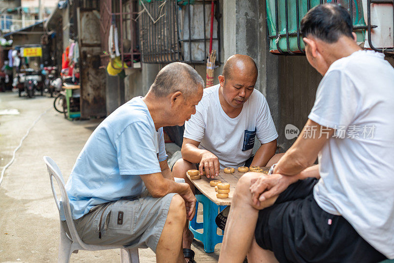 三个中国老人在街上下象棋