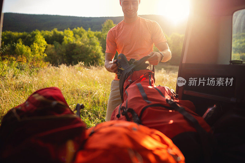 微笑的登山者把登山装备装进背包