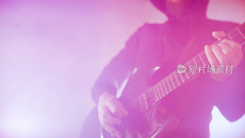 重金属摇滚吉他手在舞台灯光下表演吉他