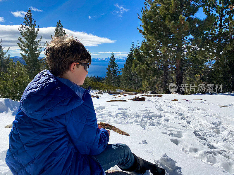 在太浩湖的森林里，人们和孩子们在雪地里和野山雀玩耍。