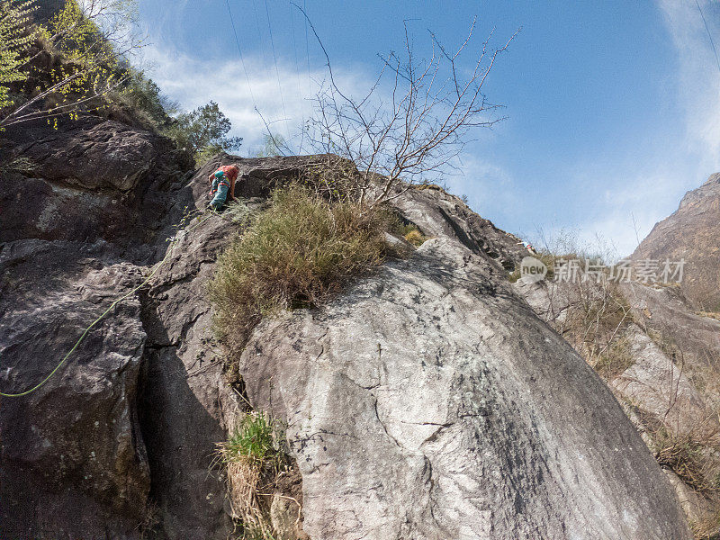 登山者攀登岩面，低角度观看