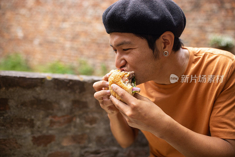 一名日本男子在后院享受美味汉堡的味道