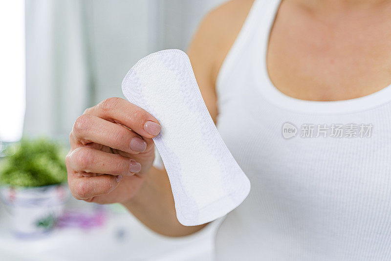 妇女手拿卫生巾的特写