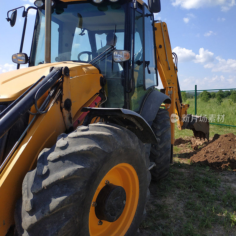 挖掘机在工地上挖掘沟渠，近距离工作的过程。