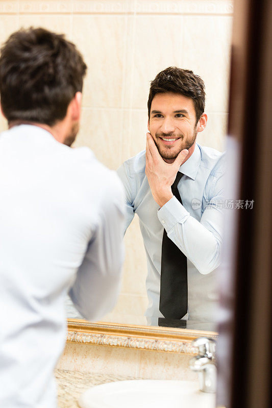 男人看着浴室镜子里的自己