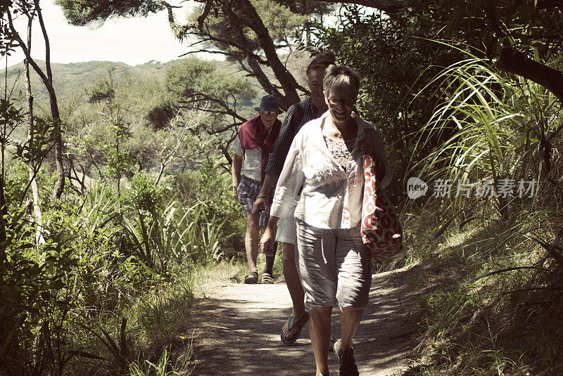 新西兰，老人们穿过灌木丛小径前往瓦拉里基海滩