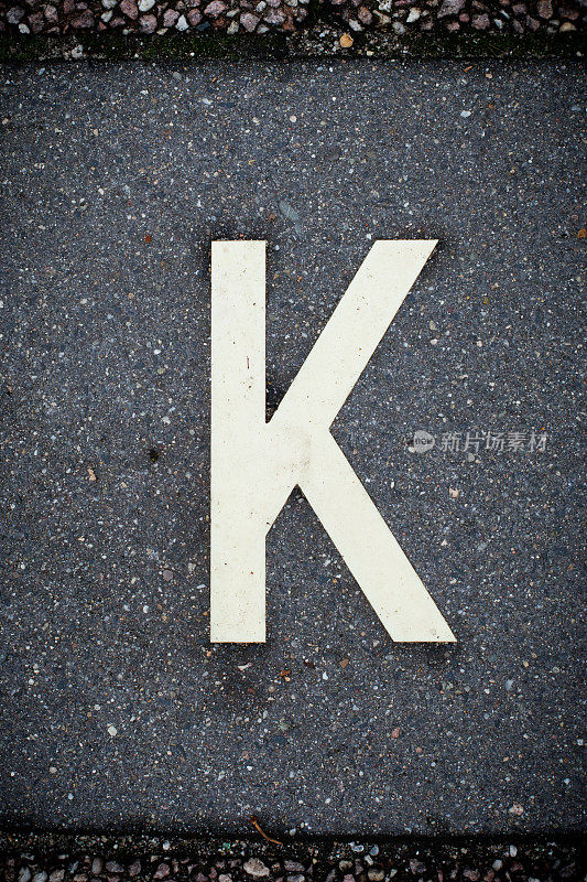 白色字母K在柏油路上。