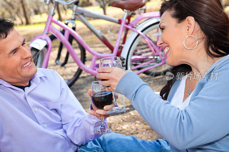 快乐的夫妇有饮料在野餐