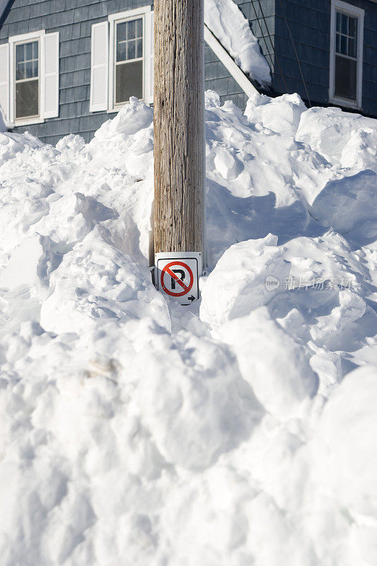 “禁止停车”的牌子被埋在雪堆里。