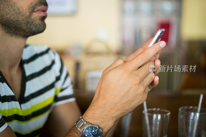 一名男子在咖啡店拿着智能手机