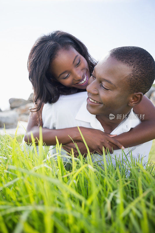 一对幸福的情侣一起躺在草地上