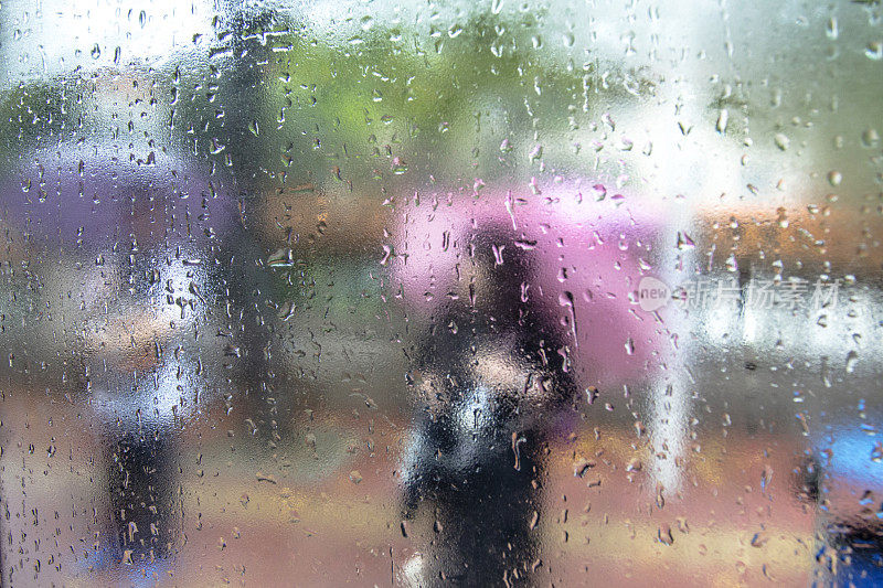 雨点落在窗户上，从车里看到行人