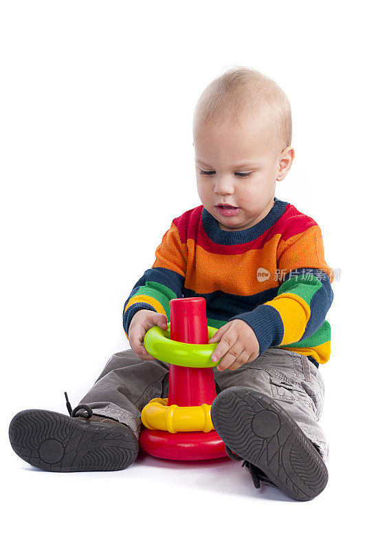 好玩的白种人婴儿学步在孤立的背景与玩具