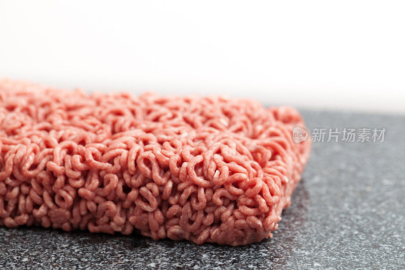 宏观特写生汉堡碎牛肉在花岗岩砧板上