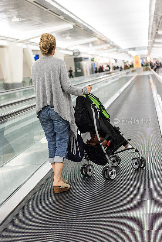 在机场推着婴儿车的女人