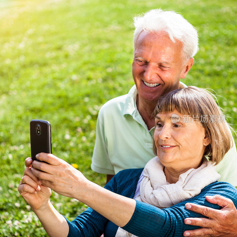 成熟的情侣用现代智能手机拍照