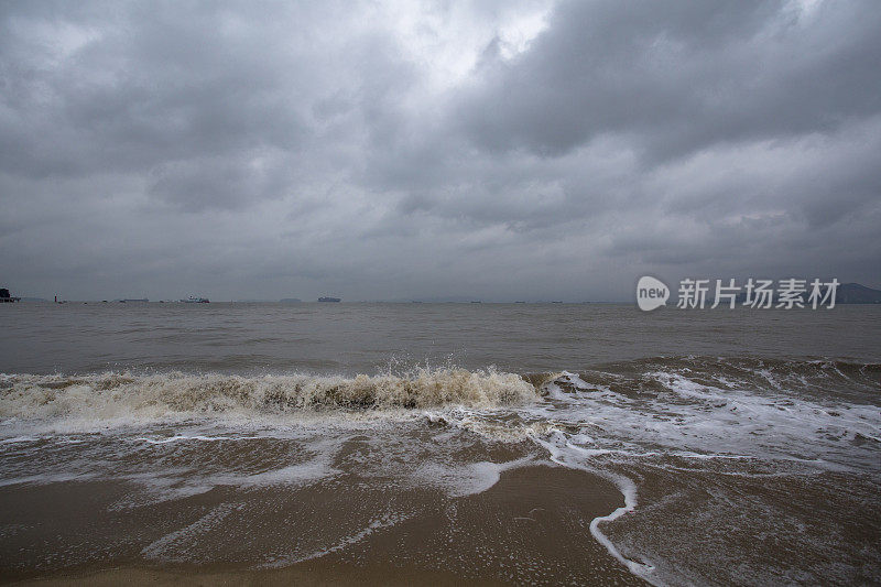 阴天下海浪在海滩上冲浪