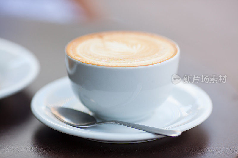 自然光线照片卡布奇诺咖啡饮料与泡沫。