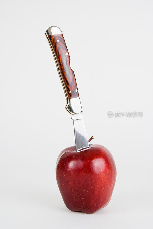 白色的苹果上插着刀