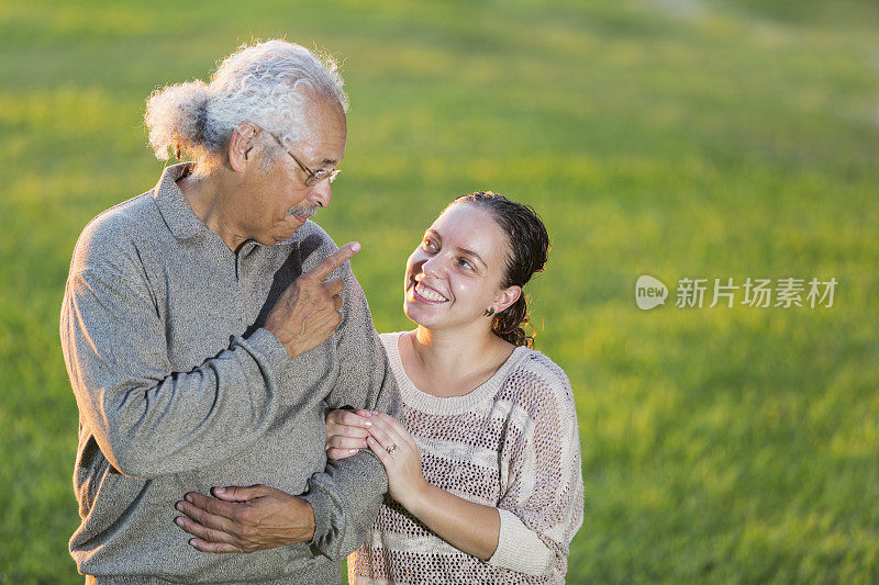 西班牙裔父亲和成年女儿在户外聊天