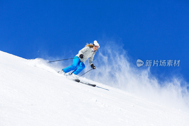 在阳光明媚的滑雪胜地滑雪的中年妇女滑雪