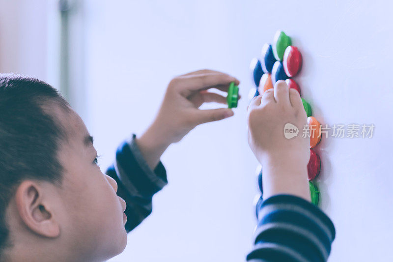 亚洲儿童用磁铁学习单词