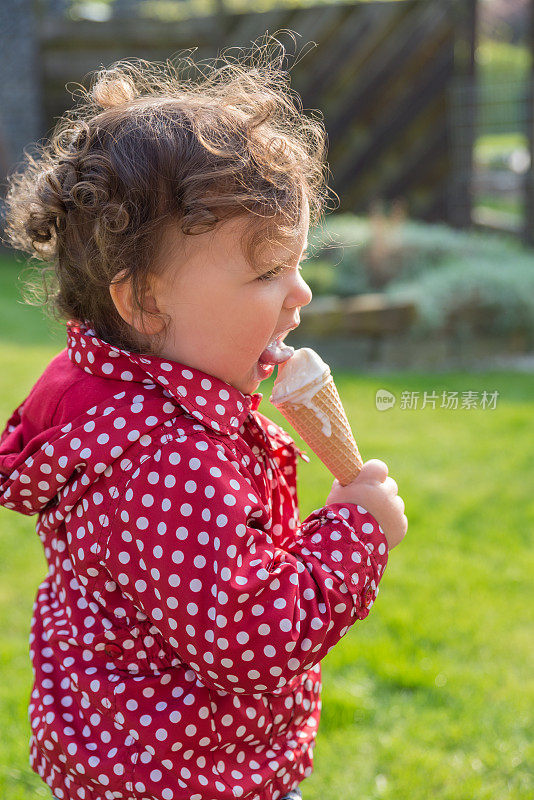 甜美的女孩在户外吃冰淇淋