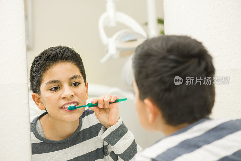 一个十几岁的男孩正在牙医诊所刷牙